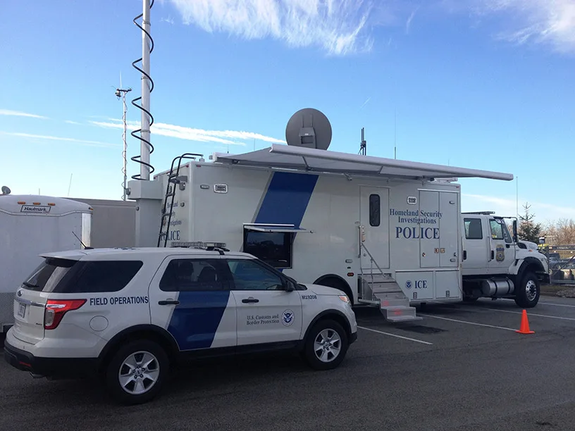 Frontline Communications DHS ICE C-38X Investigations unit parked outside in a parking lot on a sunny day.