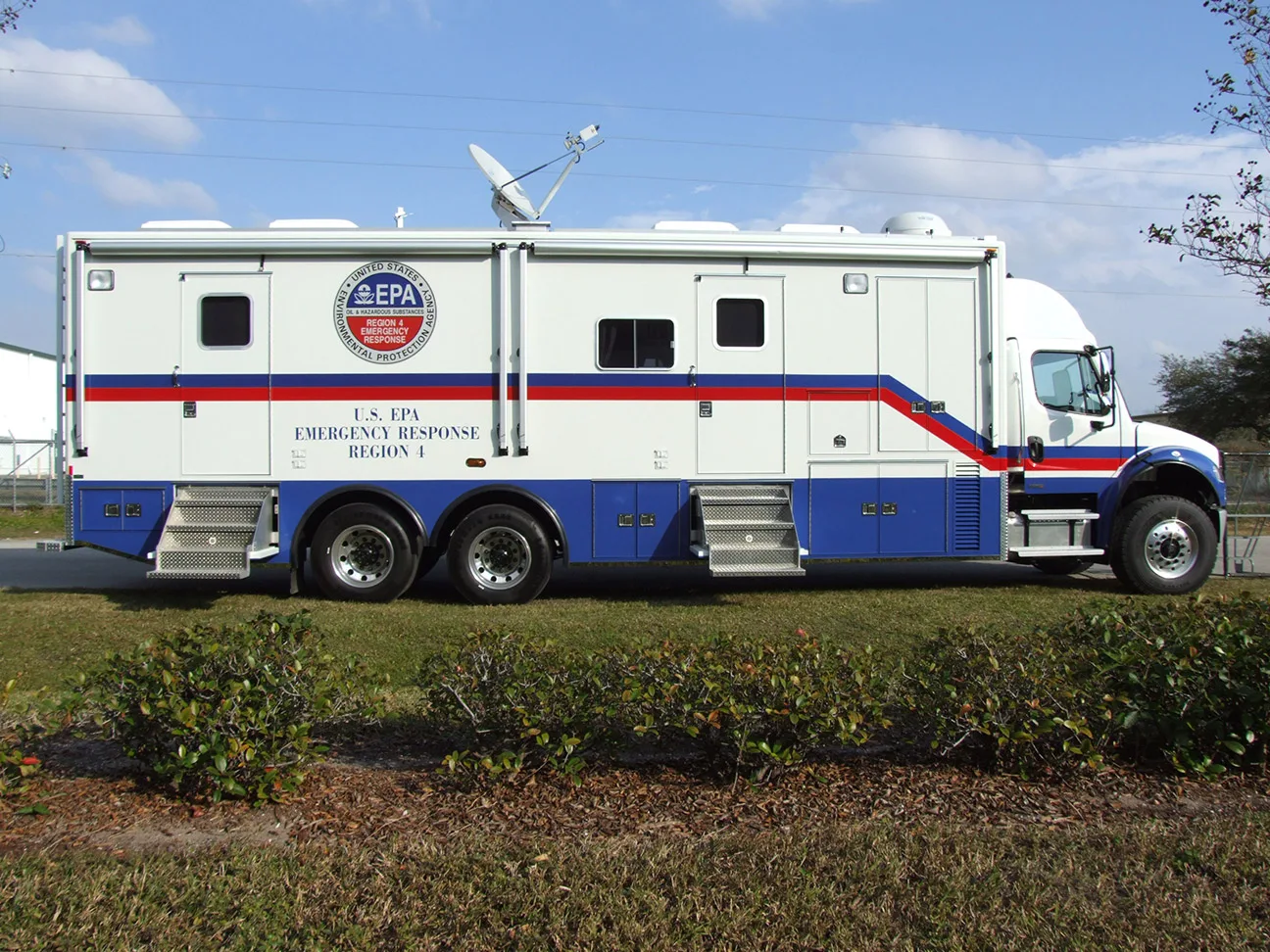 EPA C-40X-2 Emergency Response vehicle parked outside near the Frontline Communications building on a cloudy day.