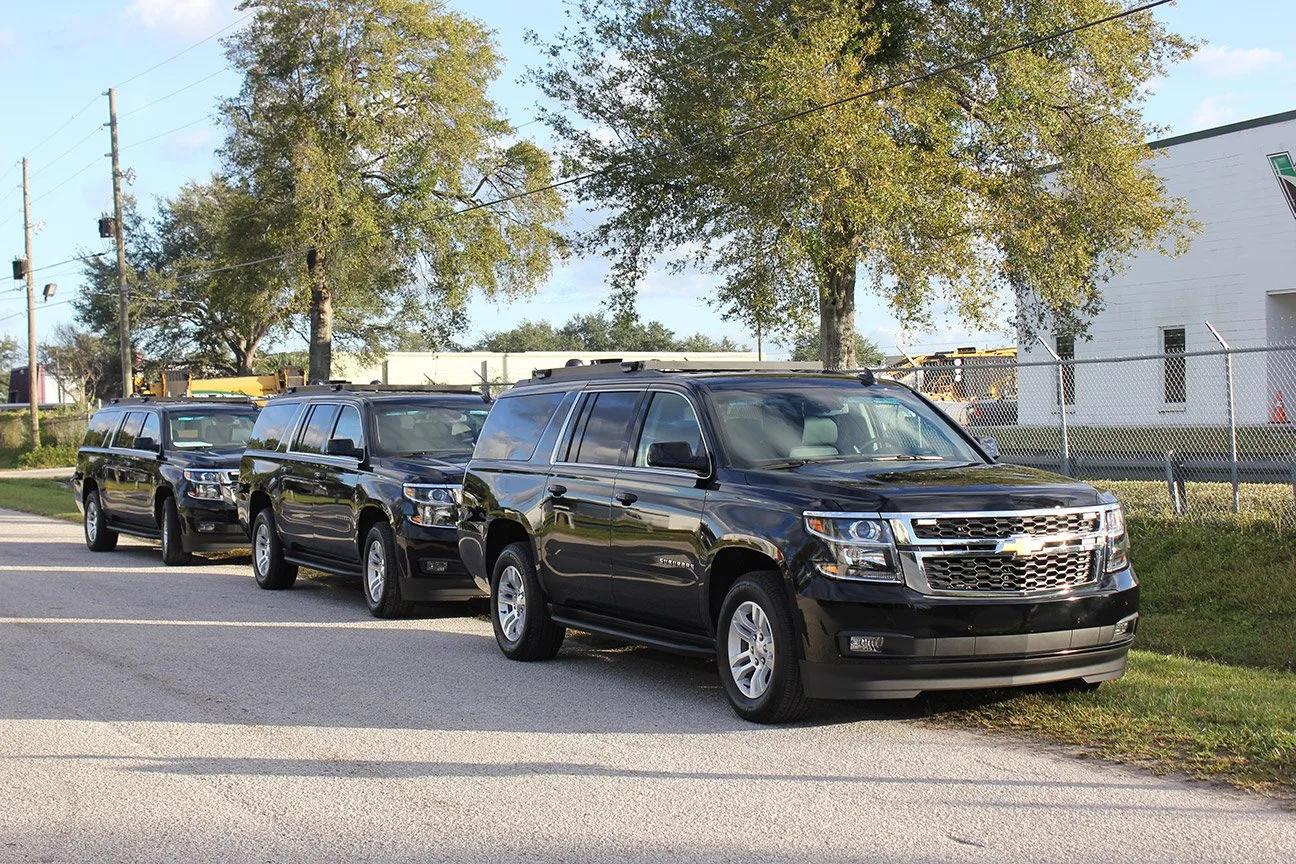 Three US Postal Inspection Service C-20T and C-17 Mobile Command units parked outside near the Frontline Communications building on a sunny day.