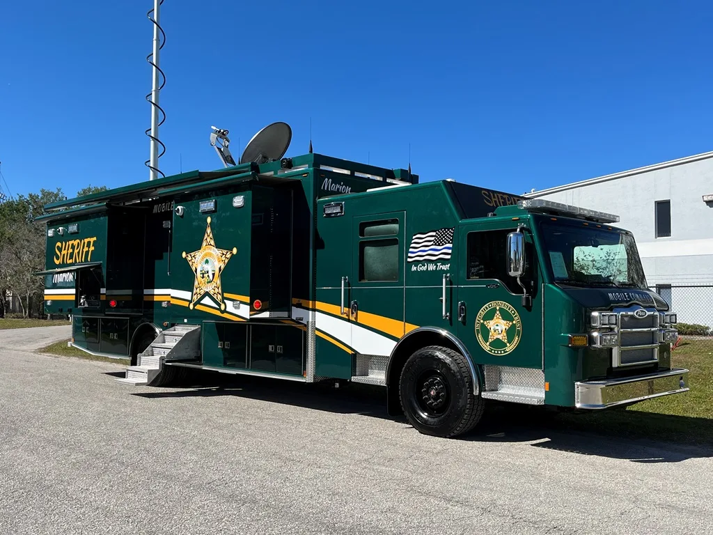 Frontline Communications C-44X-4 Large Mobile Command vehicle for Marion County Sheriffâ€™s Office parked outside near the building on a sunny day.