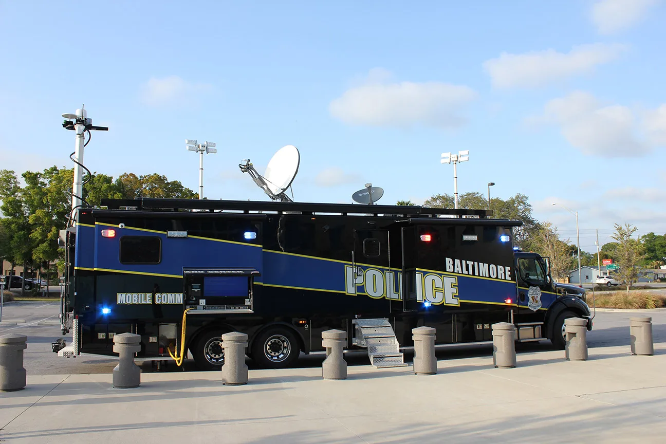 Frontline Communications C-45X-4 Mobile Command vehicle for Baltimore Police Department parked outside in a parking lot on a sunny day.