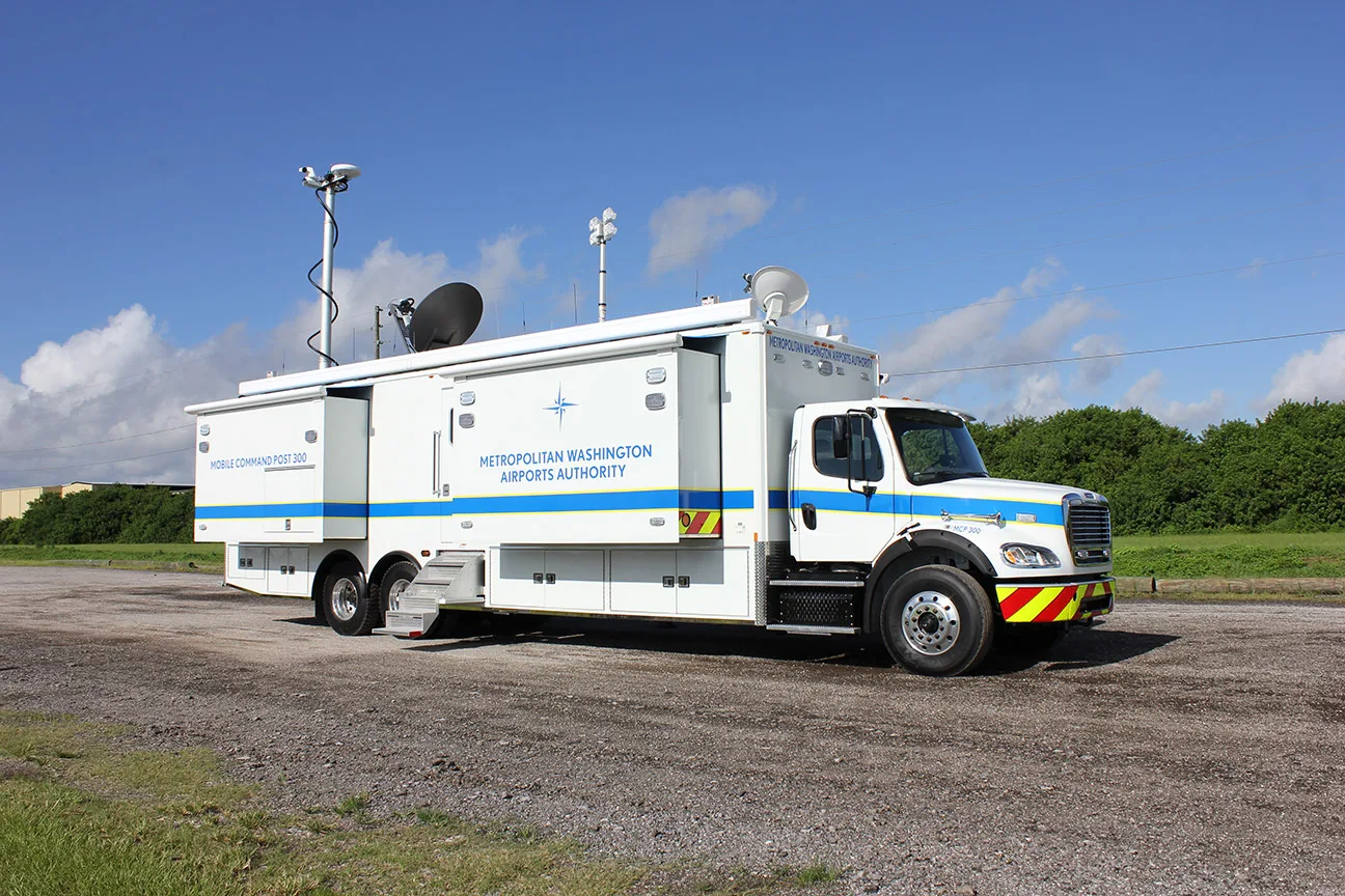 Frontline Communications C-40X-4 Mobile Command Post parked outside near trees on a sunny day.