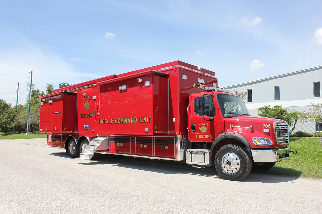 Frontline Communications red C-45X-4 Mobile Command Center parked outside the building on a sunny day.