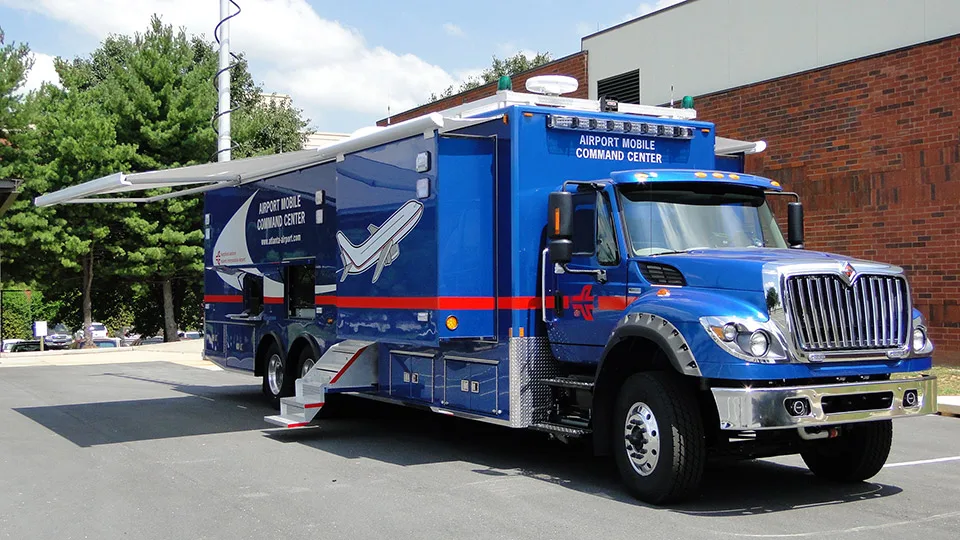 Frontline Communications C-40X-3 Mobile Command unit with the awning extended for Atlanta International Airport parked outside near a building.
