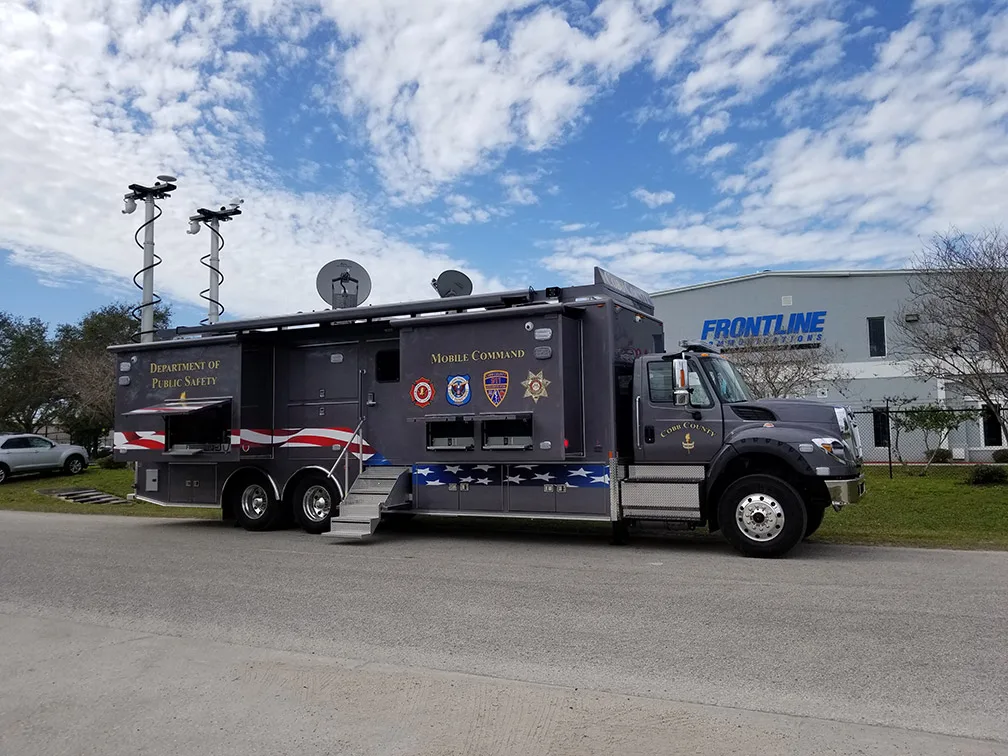 Frontline Communications C-43X-4 Mobile Command vehicle for Cobb County parked outside near the building on a cloudy day.