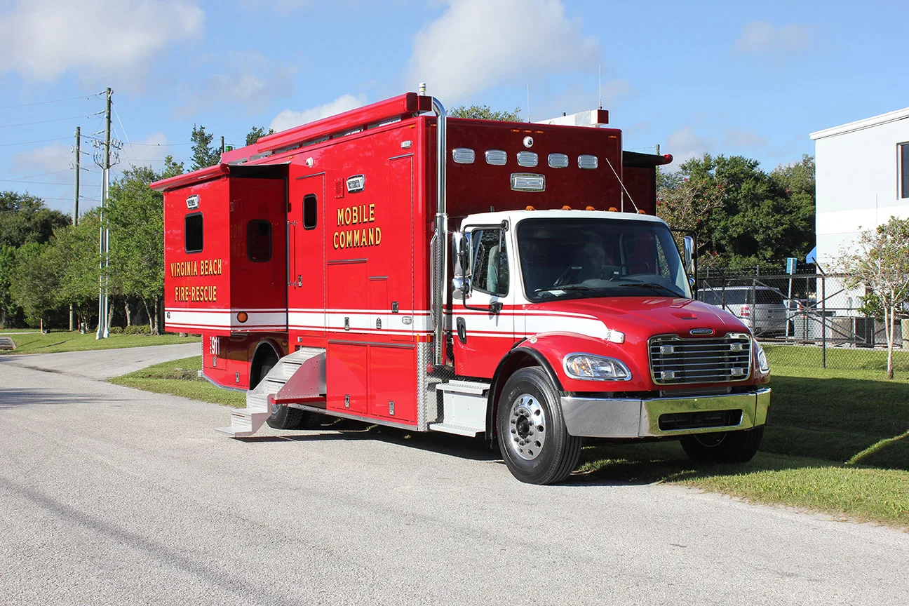 C-32X-2 Mobile Command vehicle parked outside near the Frontline Communications building on a sunny day.