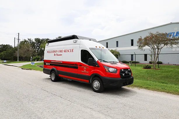CRU Transit Rehab unit parked outside near the Frontline Communications building on a cloudy day.