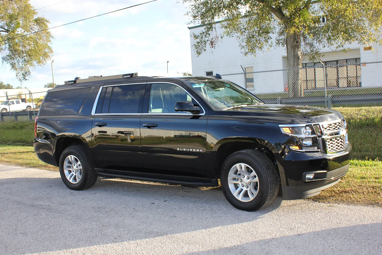 United States Postal Inspection Service vehicle parked outside near the Frontline Communications building on a sunny day.