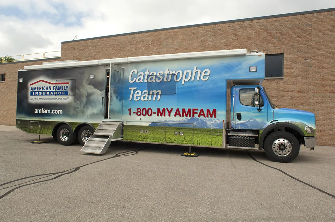 Frontline Communications C-40X Specialty Mobile Command unit parked outside near a building on a cloudy day.