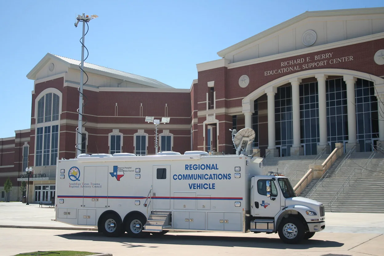 Frontline Communications C-40X-2 Regional Communications Vehicle parked outside near a building on a sunny day.