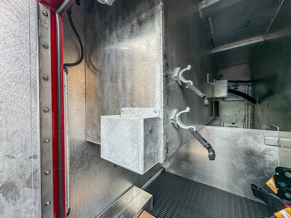 Tall open compartment with internal shelf and side fittings.