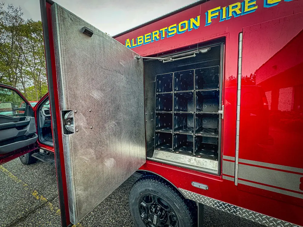 Open side cabinet with stacked black charging docks.