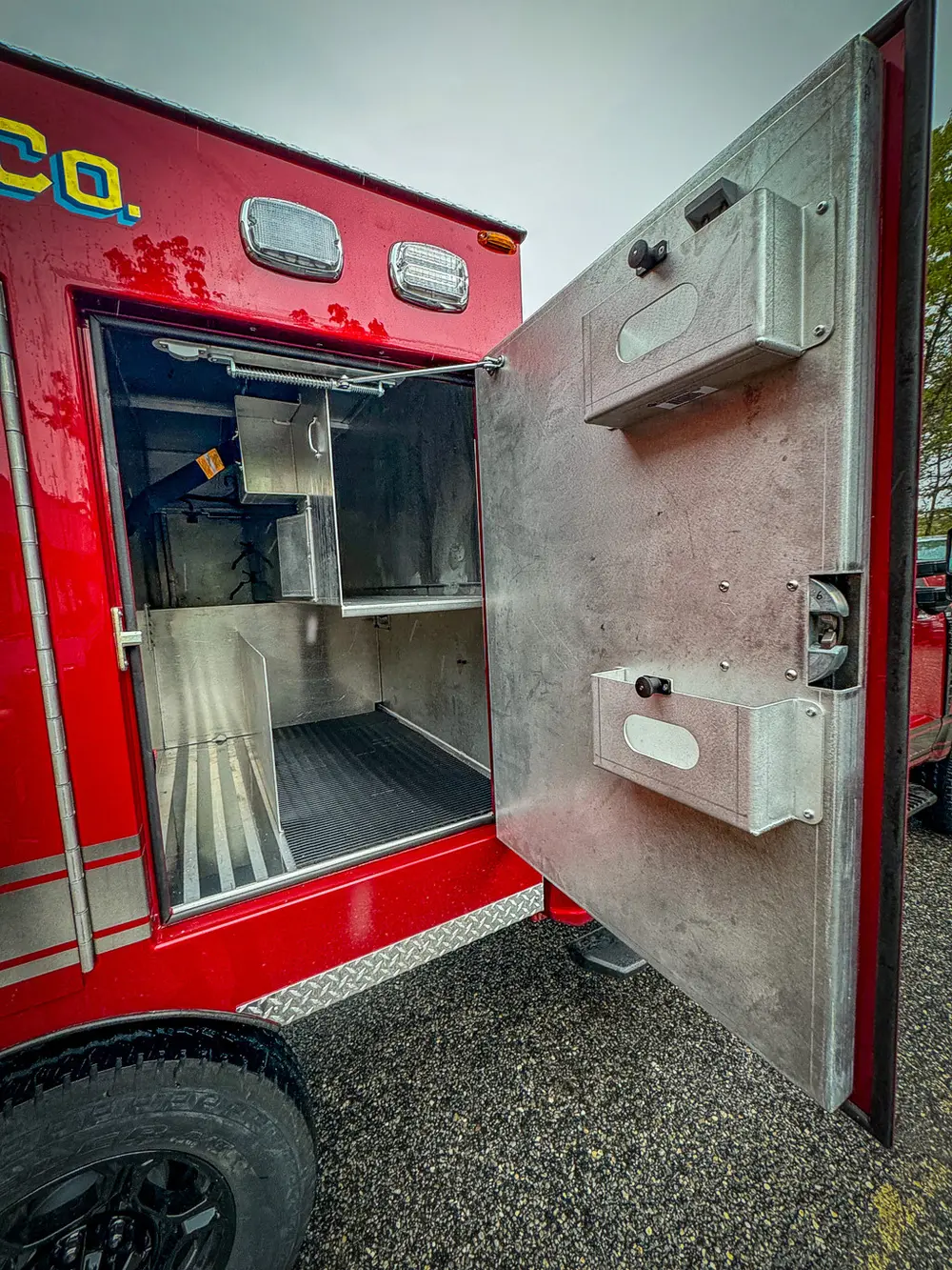 Compartment door interior with mounted outlet and handle.