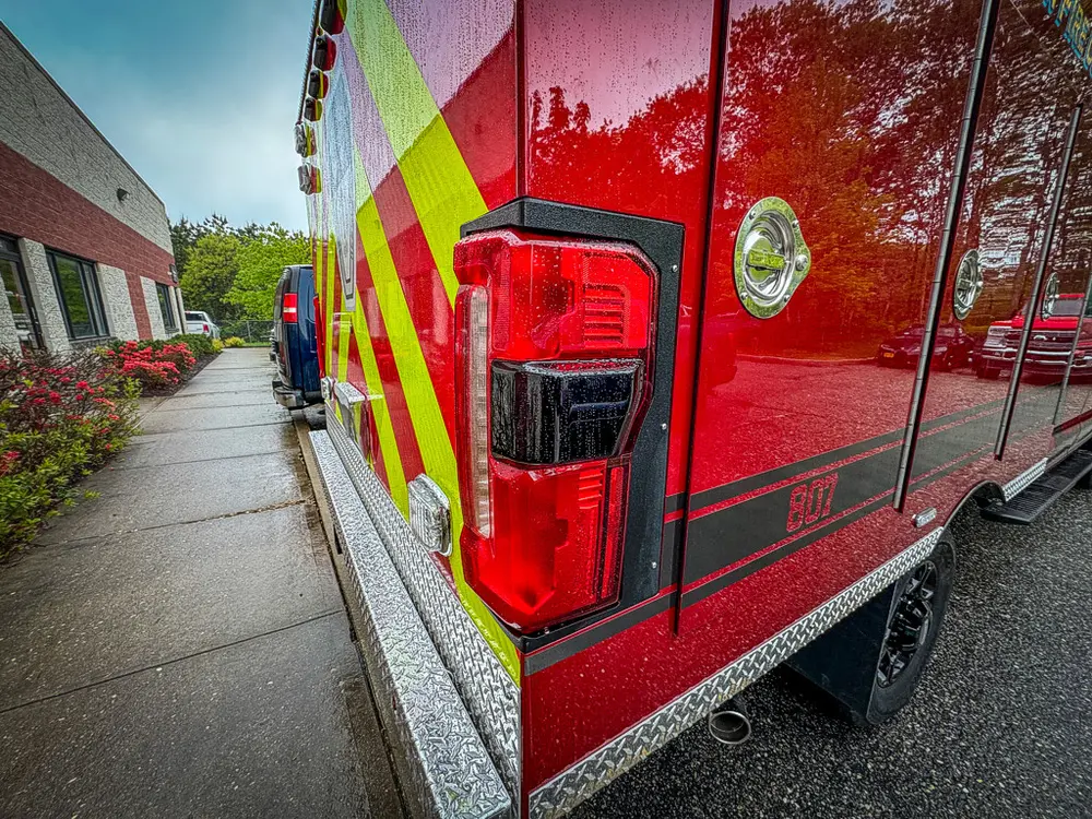 Rear corner taillight cluster on red body side panel.