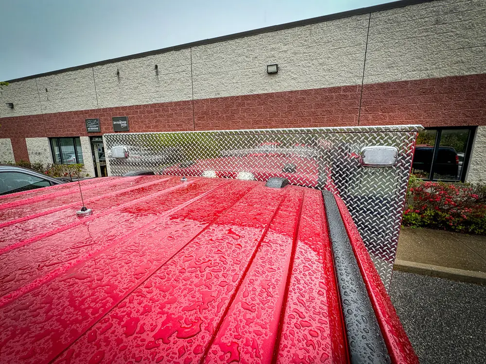 Wet red cab roof with mesh rack and light bar base.