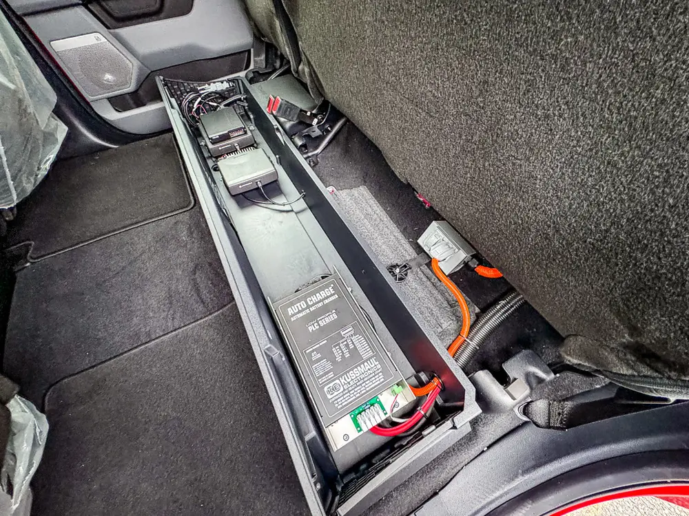 Under-seat equipment tray and wiring in rear passenger area.