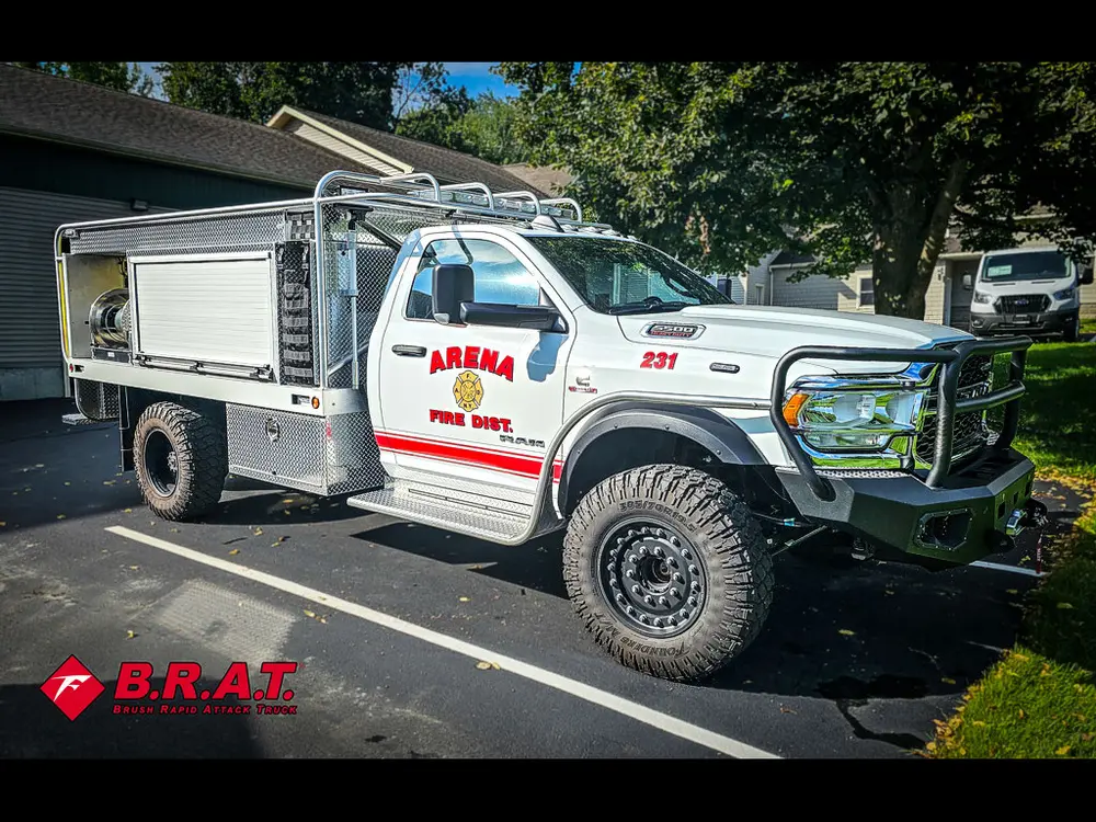 Front driver-side three-quarter view of white brush truck in parking lot.