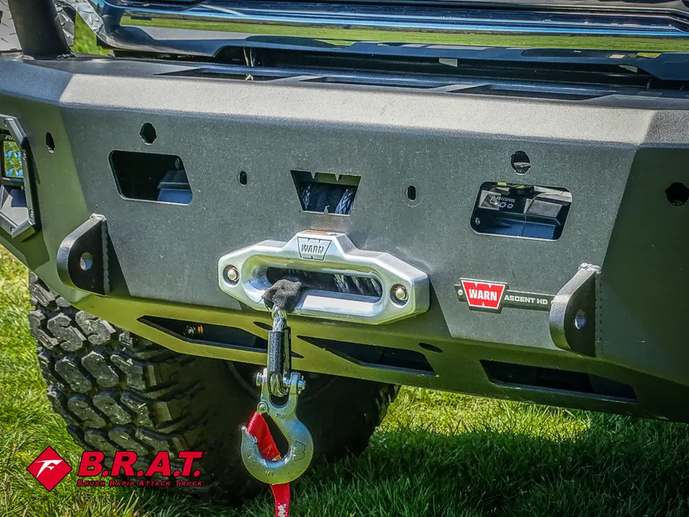 Front bumper with winch hook points and tow hardware.