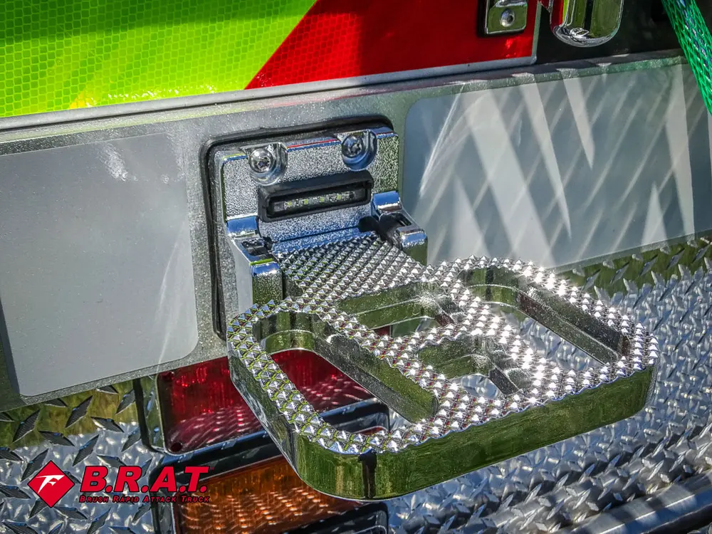 Fold-out rear corner step platform with textured surface.