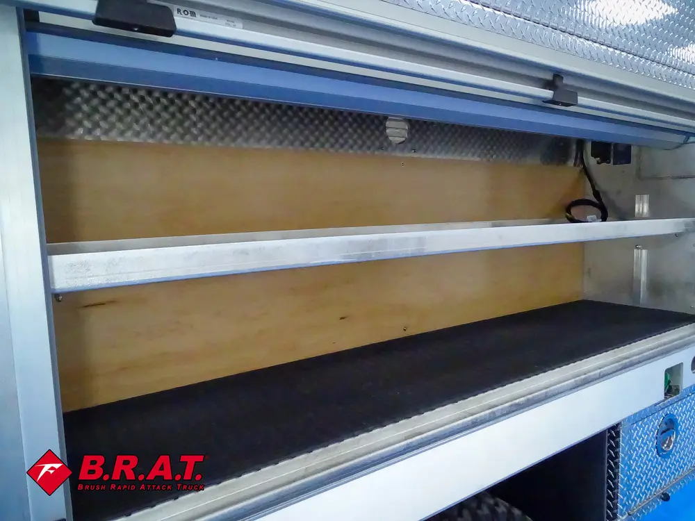 Long side compartment with sliding shelf and wooden panel backing.