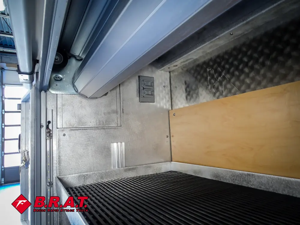 Deep side compartment interior with shelf track and black flooring.