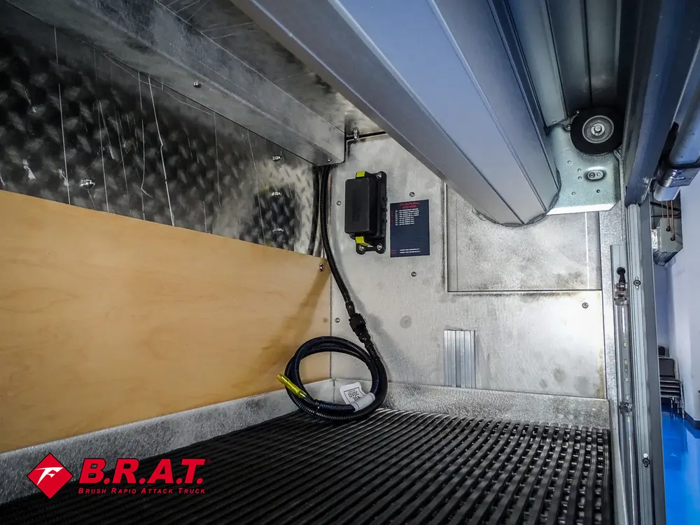 Compartment interior with overhead light and mounted battery unit.