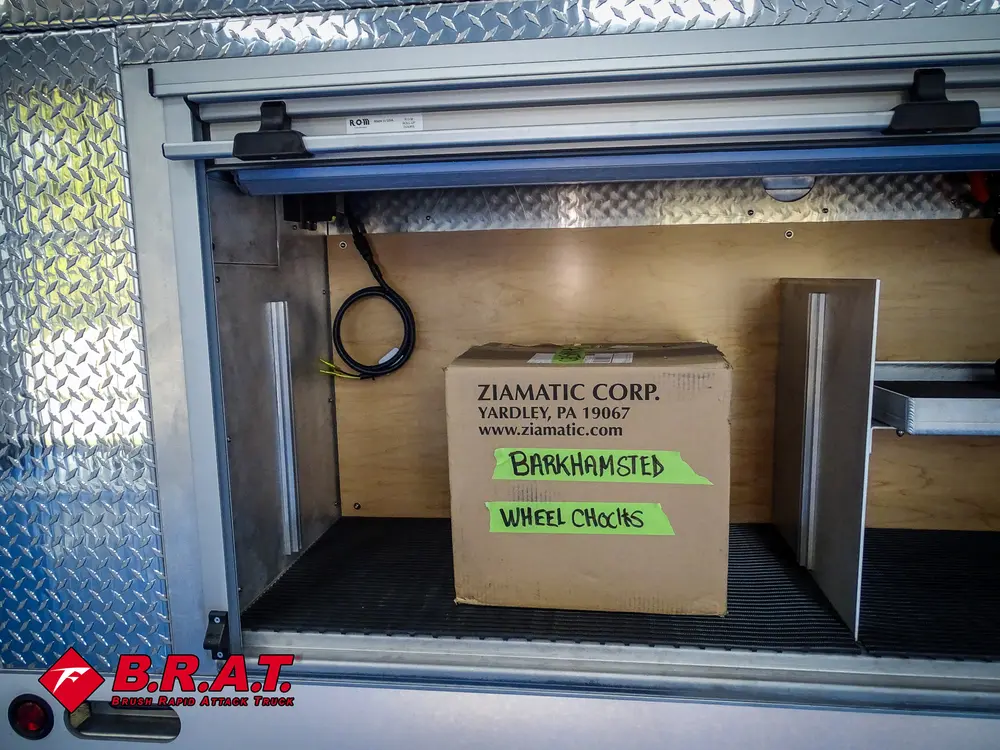 Shelf compartment with cardboard box and battery unit mounted overhead.