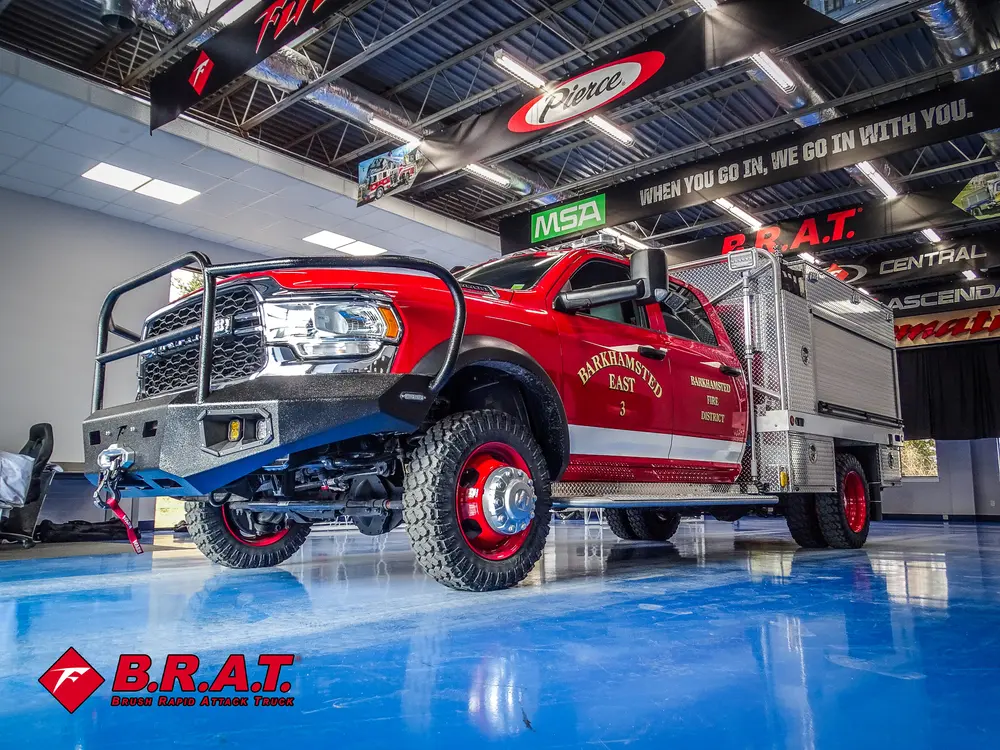 Driver-side front three-quarter view inside garage with light bar on roof.