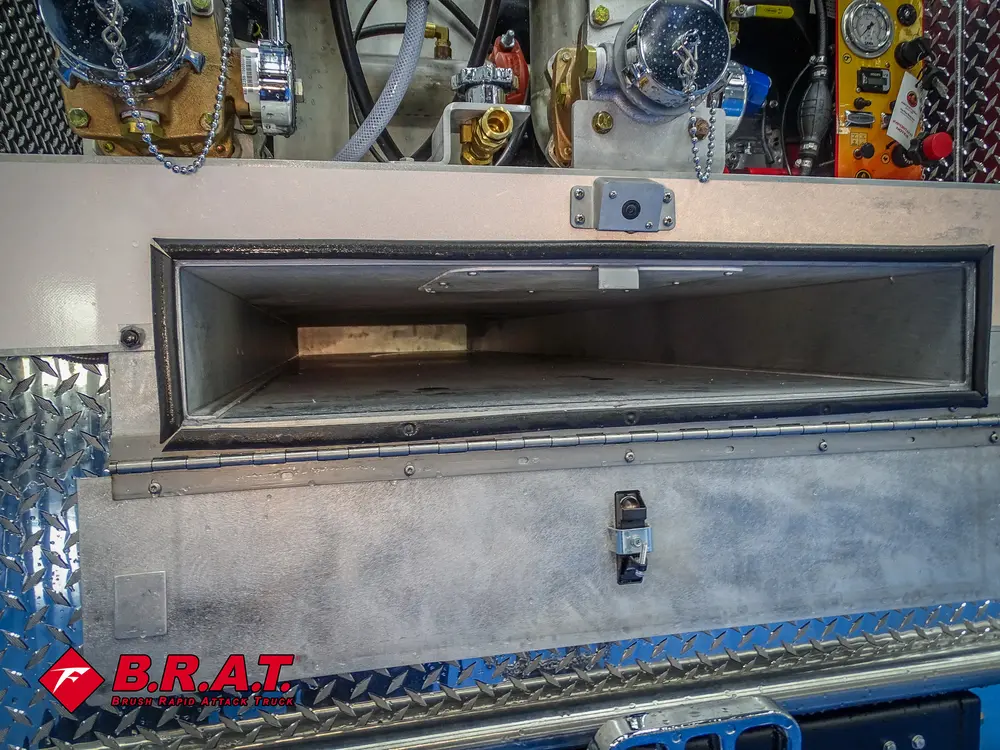 Long narrow rear bumper storage compartment open.