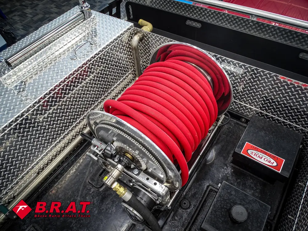 Red hose reel mounted on rear deck with metal frame.