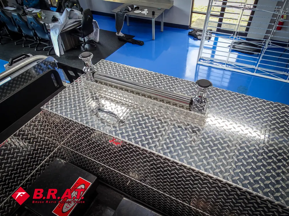 Rear deck walkway with diamond-plate surfaces and side rails.