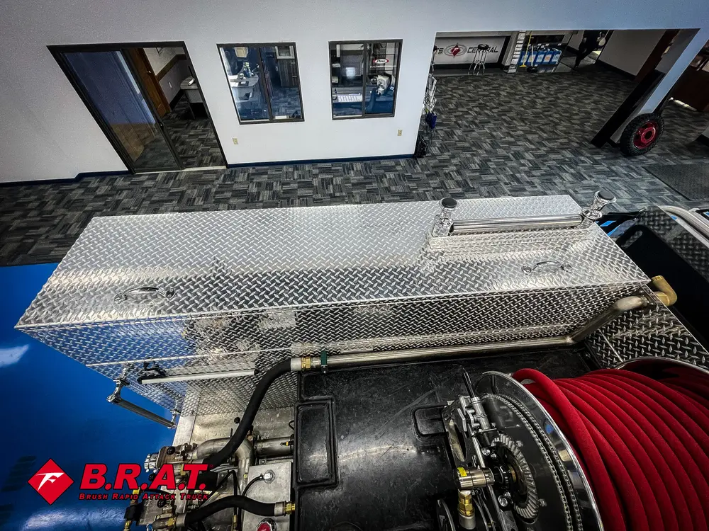 Top deck with open storage lid and hose reel below.