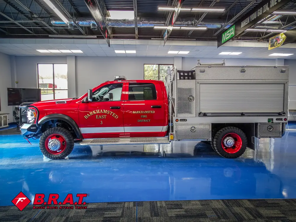 Full driver-side profile inside garage with utility body compartments.