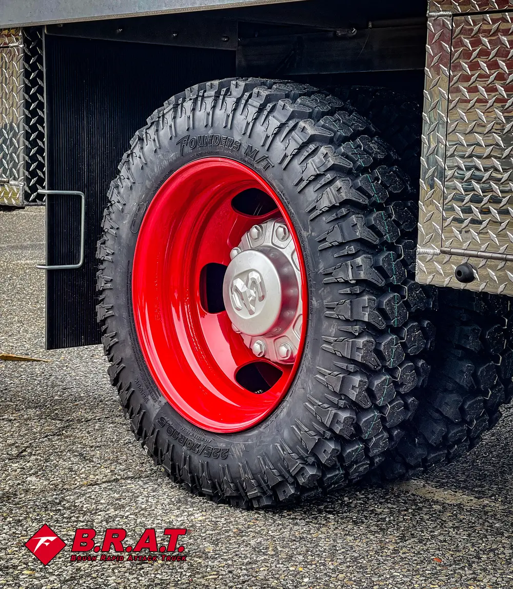 Second close-up of treaded tire and red wheel rim.