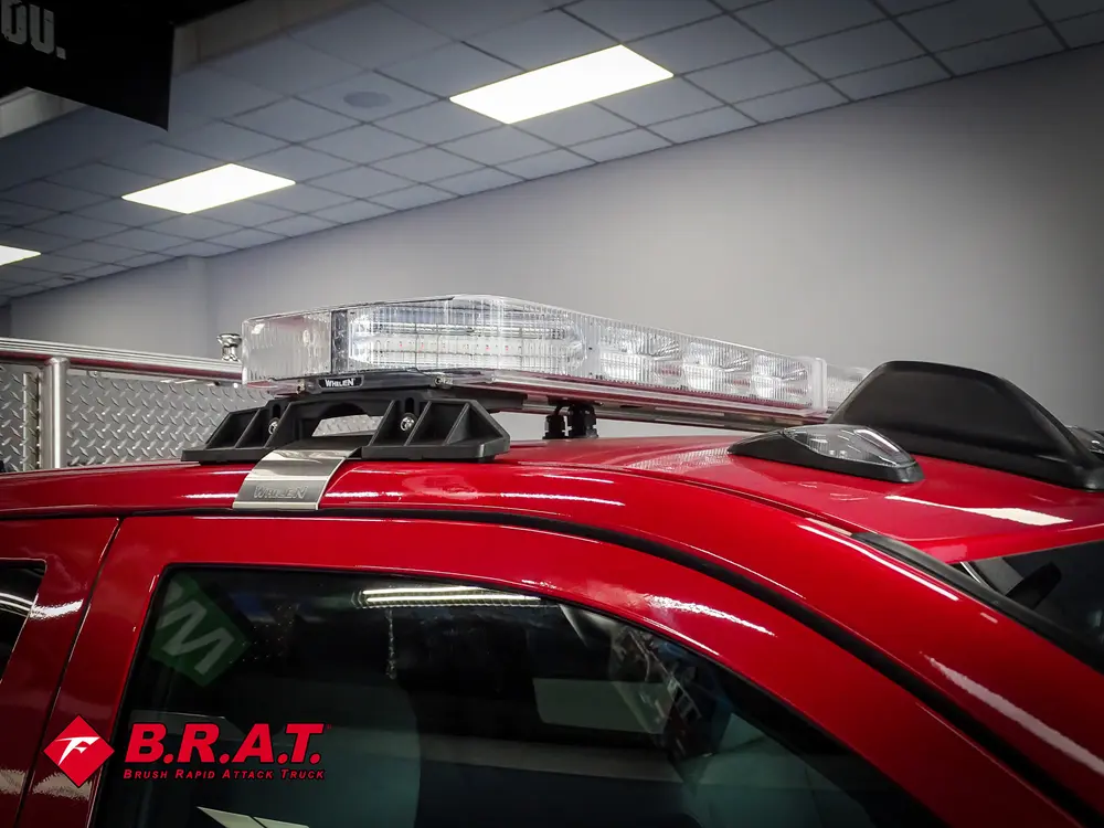 Roof-mounted light bar and black rack rails above cab.