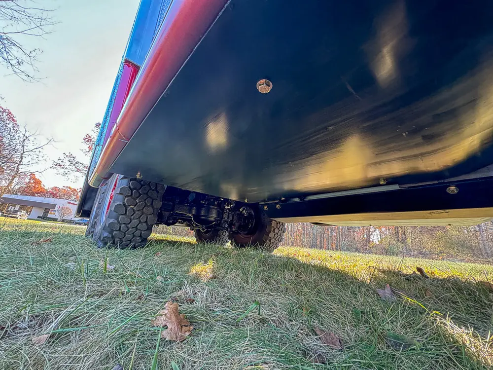 Low underbody view showing long side panel and chassis underside.