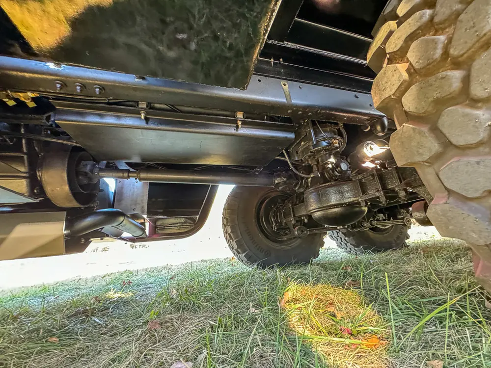 Front undercarriage view near axle and oversized tire tread.