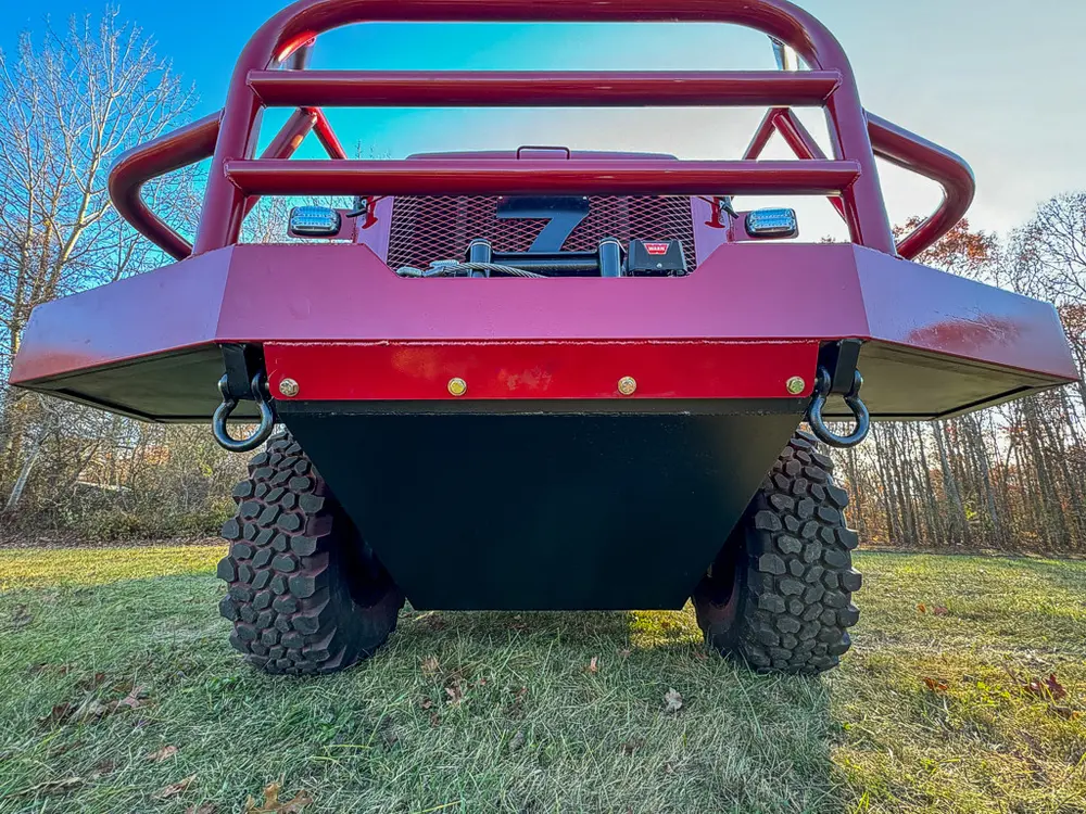 Low head-on view of the front bumper and oversized off-road tires.