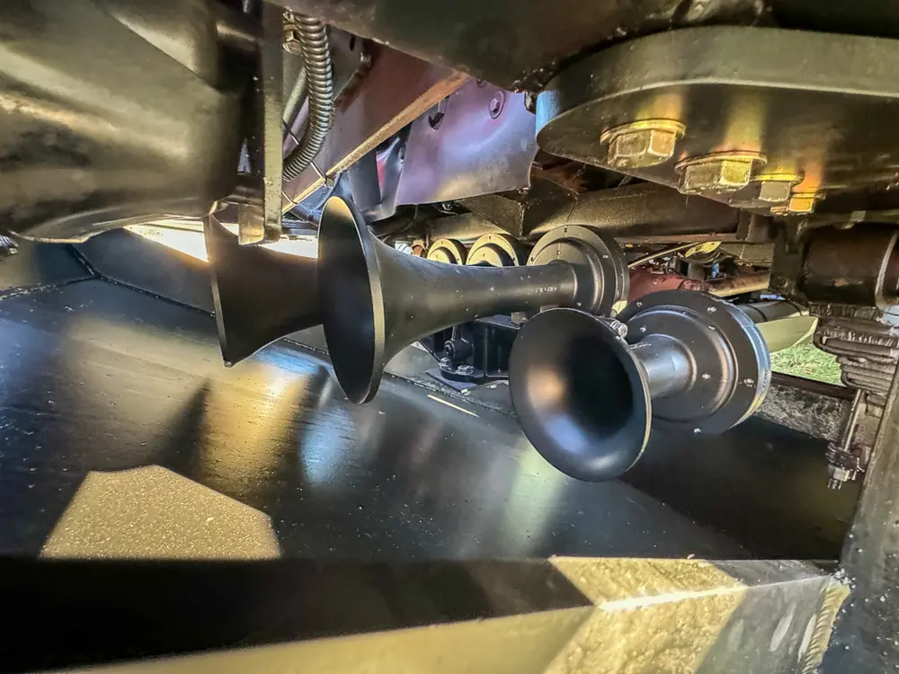 Lower side underbody close-up with black outlet pipe and fittings.