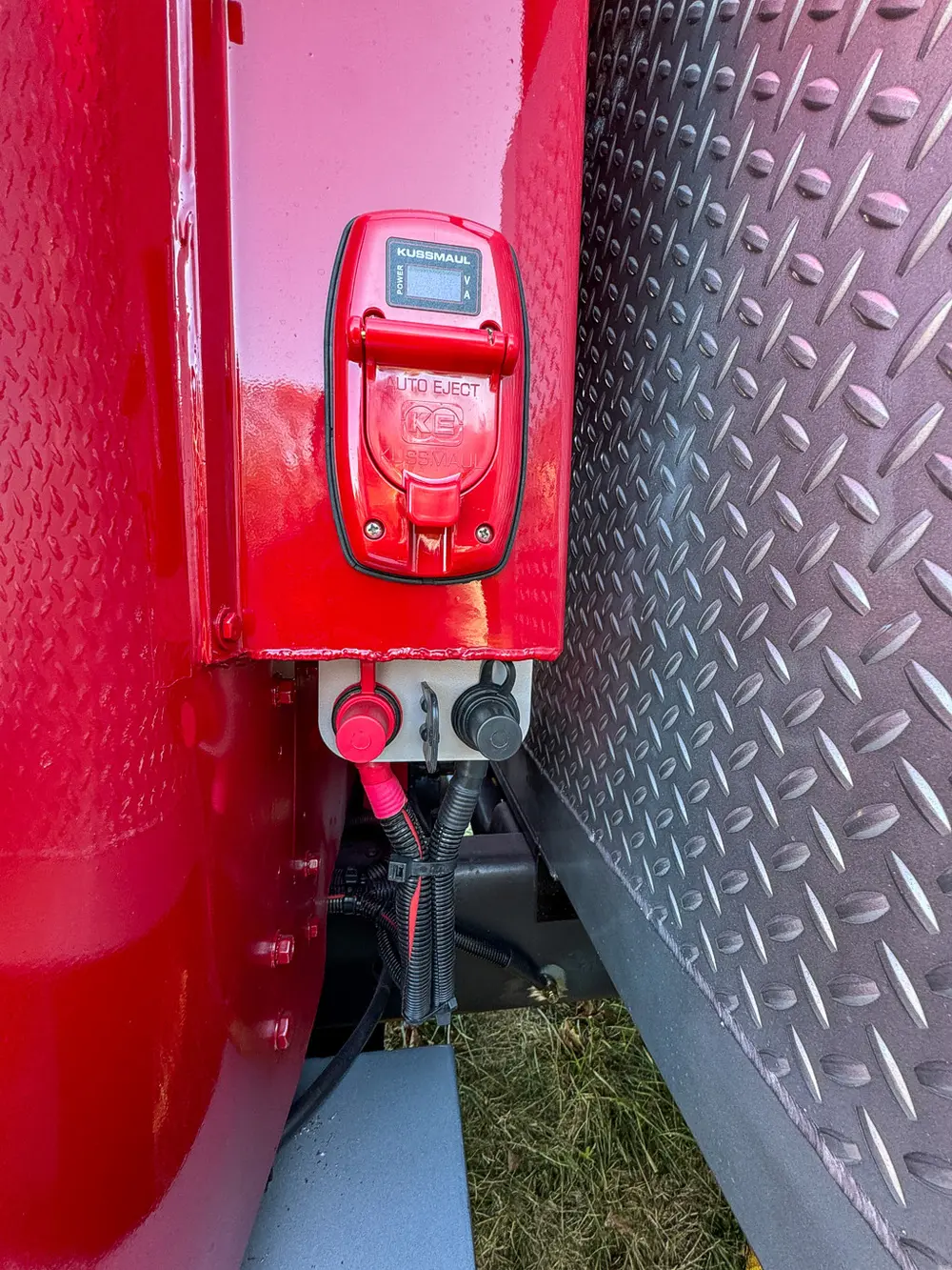 Rear corner close-up with taillight and lower electrical connectors.