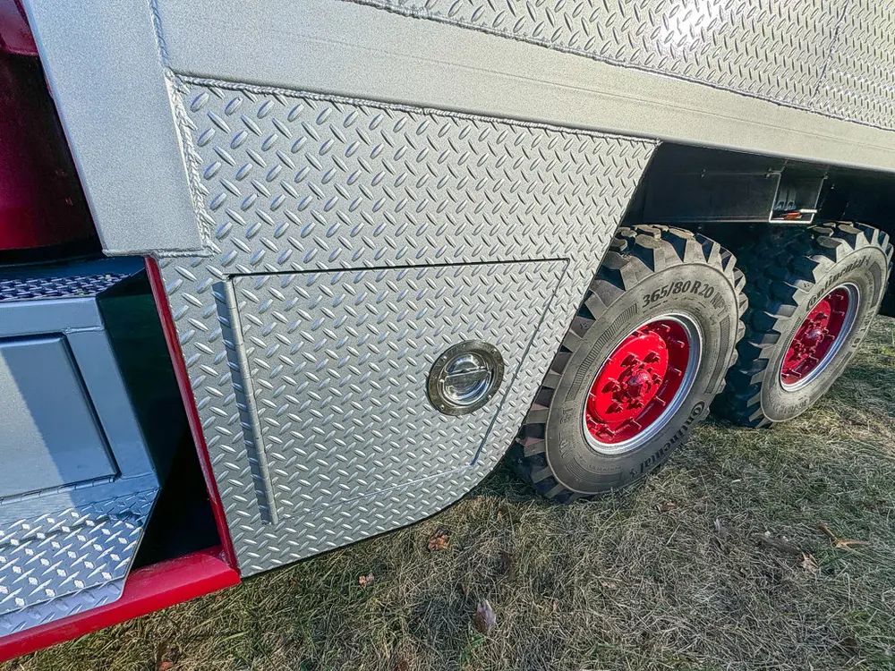 Diamond-plate side body and tandem rear wheel close-up.