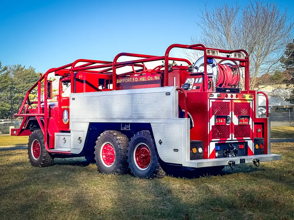 Rear-left three-quarter view showing hose reel and rear platform.
