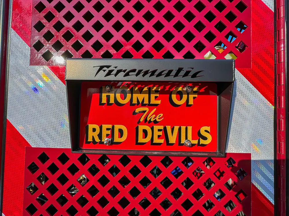 Rear mesh panel close-up with Home of the Red Devils sign.