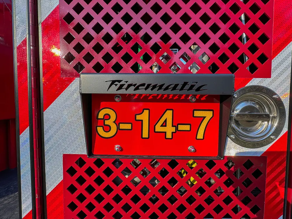 Rear panel close-up with number plate on red mesh background.