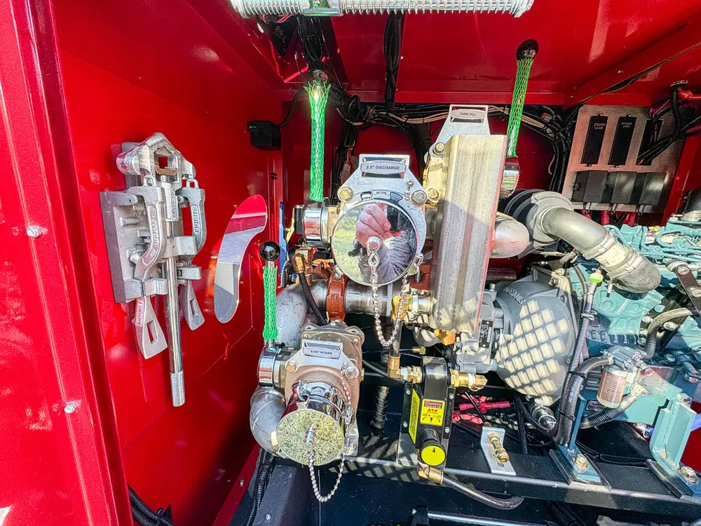 Pump and plumbing cluster close-up inside rear equipment bay.