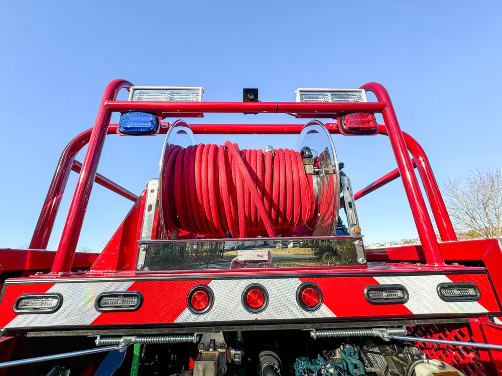 Rear upper deck view centered on red hose reel and rail frame.