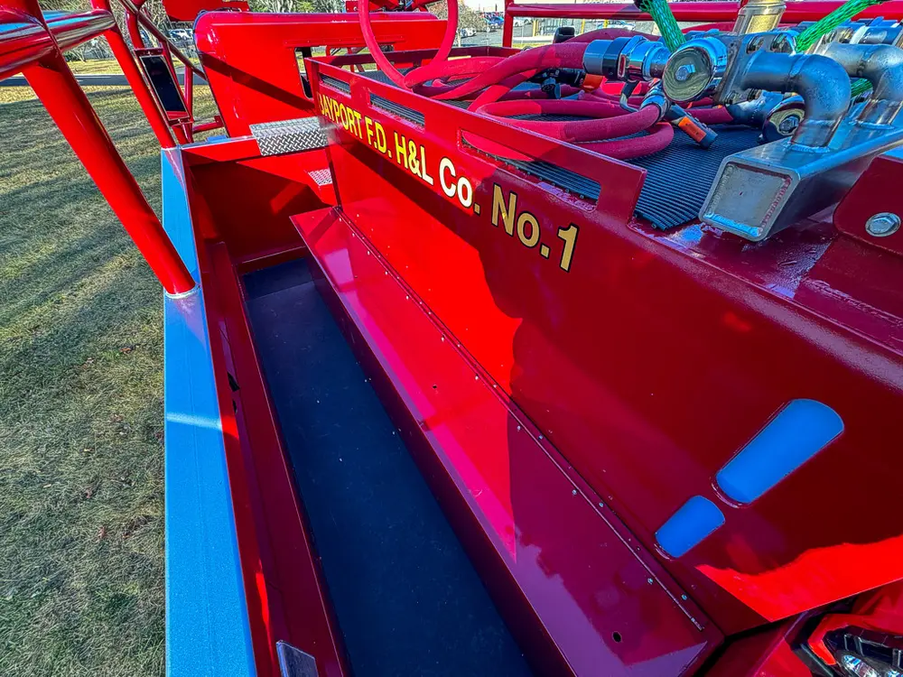 Long top-side compartment with hoses and tools stored along the rail.