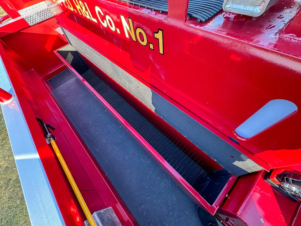 Open top-side compartment with dark floor and white side markers.