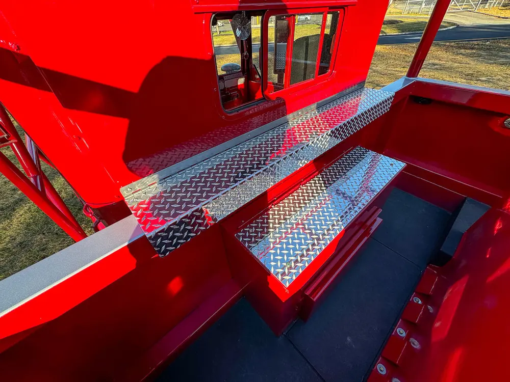 Upper side walkway with fold-down compartment door and diamond-plate trim.