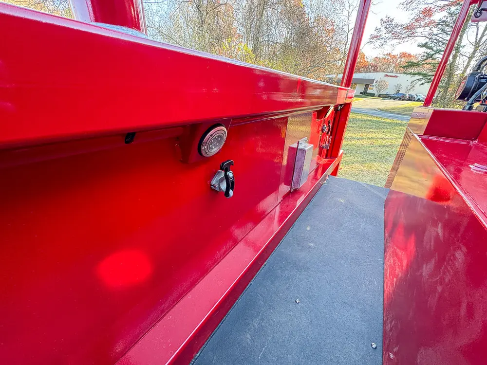 Upper side panel close-up with latch on smooth red compartment door.